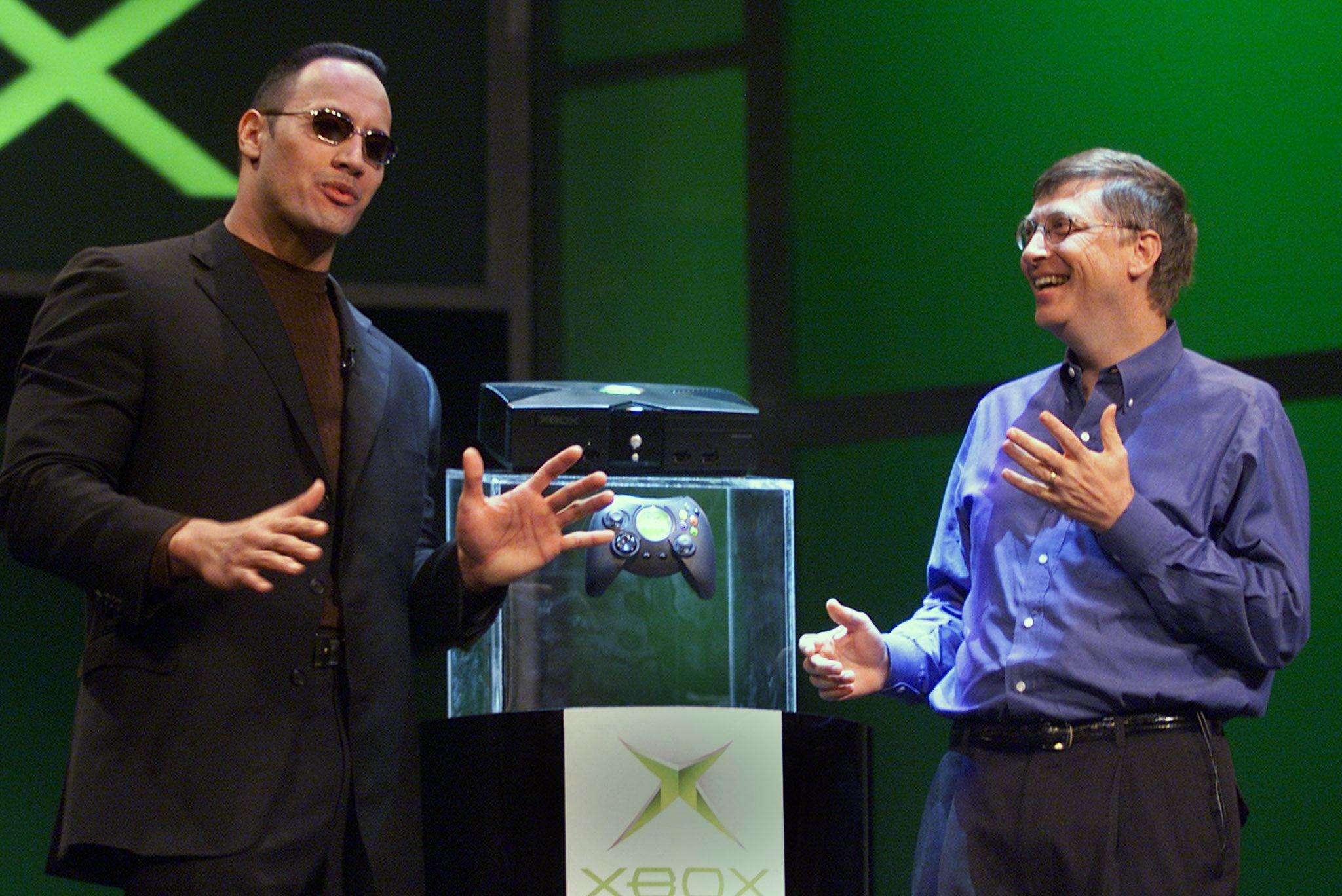 Bill Gates of Microsoft (R) speaks with World Wrestling Federation star "The Rock" after Gates unveiled the new Xbox video game console at the Consumer Electronics Show in Las Vegas 06 January 2001. "The Rock" will be featured in a video game when the Xbox launches in the fall of 2001. AFP PHOTO/Jeff Christensen (Photo by JEFF CHRISTENSEN / AFP) (Photo by JEFF CHRISTENSEN/AFP via Getty Images)