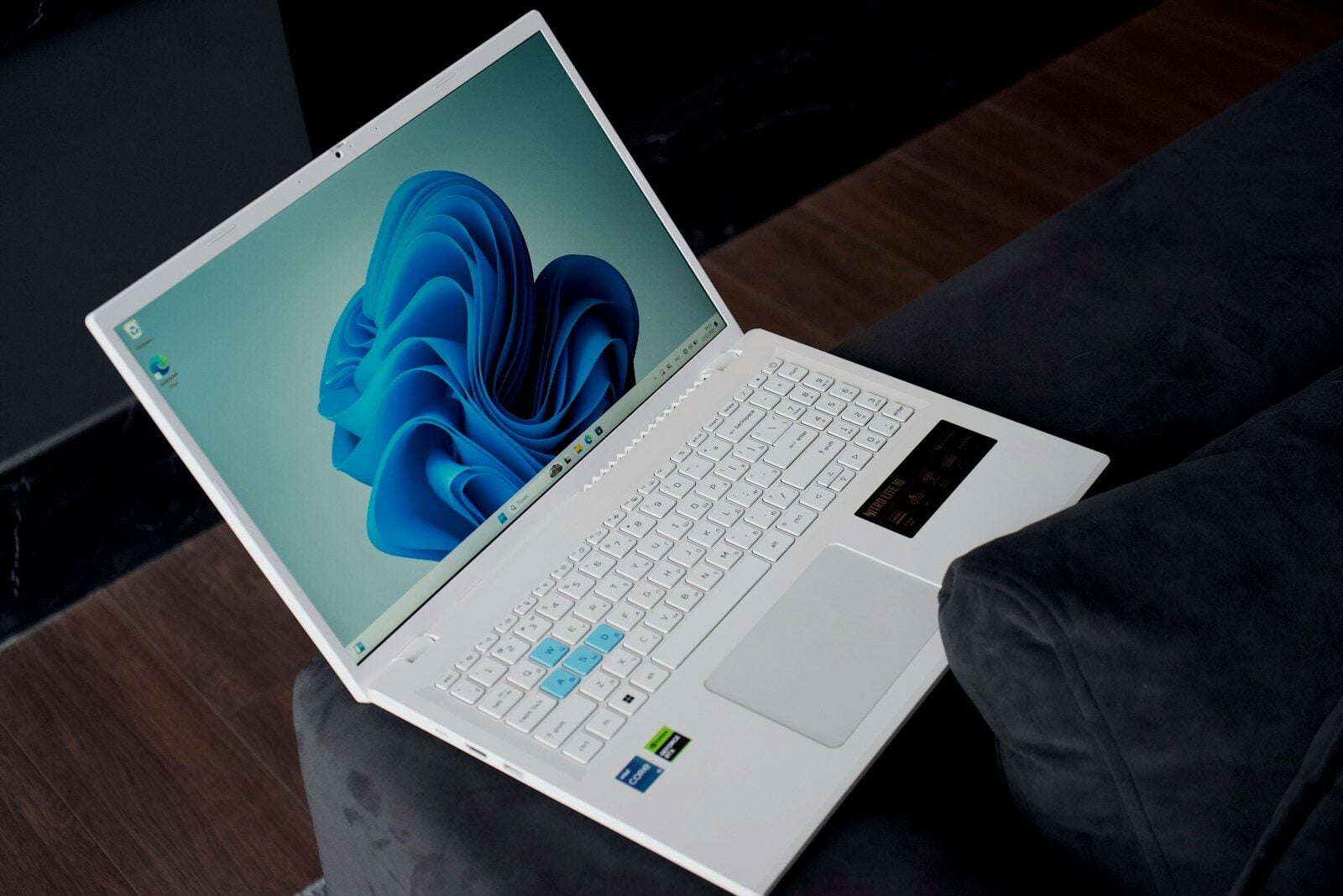 A white laptop with a blue wallpaper is open.